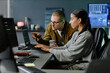 © Seventyfour - Side view of male IT programmer pointing at laptop screen helping female colleague with code debugging while collaborating at corporate workplace
