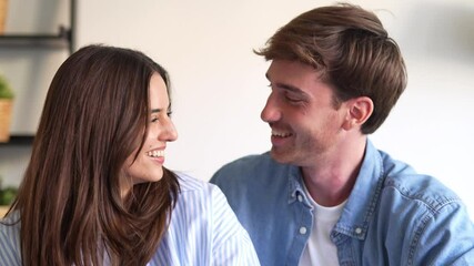 Wall Mural - Portrait of young 20s just married couple in love posing photo shooting seated on couch in modern studio apartments, concept of capture happy moment, harmonic relationships, care and sincere feelings
