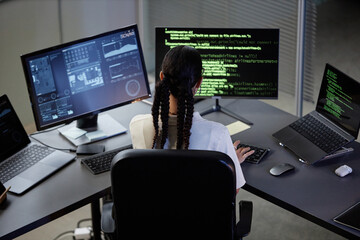 high angle shot of unrecognizable female programmer working at computer with multiple screens coding