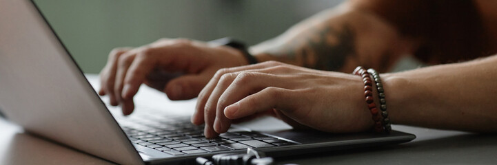 website header shot male hands typing on keyboard of laptop writing code in office, copy space