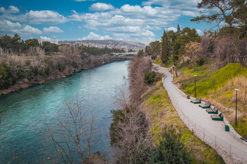 View of Podgorica with the Moraca River, surrounded by greenery, modern buildings, and hills. Montenegro