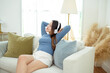 © tonefotografia - Young Asian woman wearing headphones enjoying music in living room at home