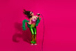 © deagreez - Vibrant young woman singing karaoke in retro-inspired colorful outfit with dynamic pose