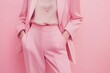 © Kassiopeia  - A sleek pastel pink tailored pantsuit is highlighted, complemented by minimalist silver jewelry. The soft blush background enhances the modern aesthetic, perfect for fashion-focused content