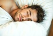 © iushakovsky - A sleeping male person on a soft, white bed