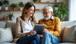 © Chad - Smiling Elderly Woman Receiving Care from a Nurse Using a Tablet in a Nursing Home