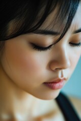 Wall Mural - A close-up shot of a woman with her eyes shut, possibly in meditation or deep thought