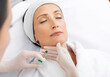 © Home-stock - Treatment with hyaluronic acid. Middle aged woman getting injection in the lower jaw, professional cosmetologist working in white gloves in salon