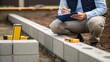 © DigitalSpace - An inspector kneeling beside a foundation studying the alignment of the concrete blocks while jotting down notes on a clipboard showcasing meticulous attention to structural