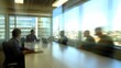 © BerkahStock - Blurred business meeting in modern office with city view.