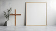 © Erika - porta retratos vacio o marco de madera con espacio de copia con una cruz de madera catolica cristiana junto a una maceta con ramas decorativas diseño minimalista