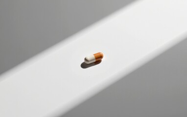 Wall Mural - A single  capsule pill resting on a clean white surface, casting a subtle shadow.