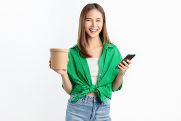 Wall Mural - Smiling beautiful Asian woman holding cardboard boxes and hands using smartphone on white background. Concept delivery online.