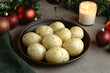 © Desna - Seasoned Boiled Potatoes with Holiday Decorations. A bowl of perfectly seasoned boiled potatoes surrounded by festive holiday ornaments, candlelight, greenery, and a glass of red wine.