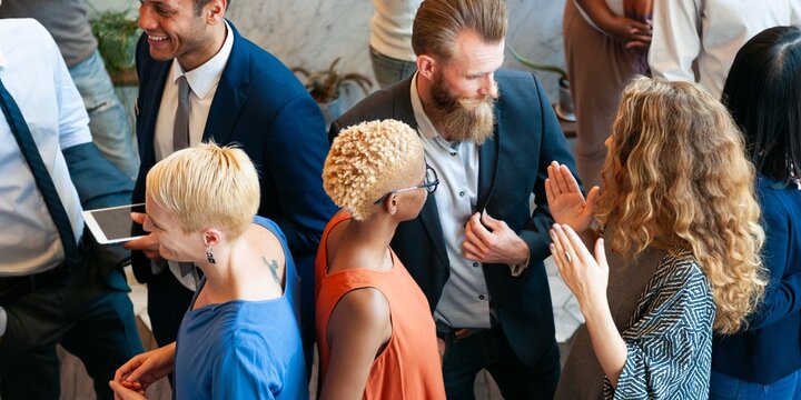 diverse group of people in business attire networking at an event. engaged in conversation, sharing 