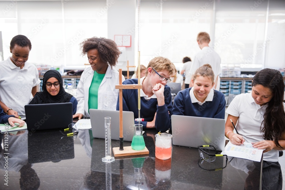 Diverse students and teacher in a science lab, using laptops and lab ...
