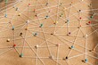 © Rawpixel.com - Colorful pins connected by strings on corkboard. Network of pins and strings. Pins and strings forming a web. Strings and pins creating connections. Connection background, business network background.