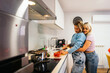 © Alberto - Lesbian couple cooking together in modern kitchen for valentine's day
