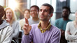 © Katsiaryna - He got some questions. Group of young people sitting on conference together while one man raising his hand