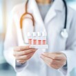 © Nidai - health check up medical early detection A healthcare professional holds a tray of test tubes filled with a pink liquid, wearing a white coat and stethoscope.