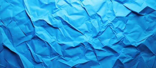 Wall Mural - Vibrant blue crumpled paper texture background featuring dynamic folds and shadows ideal for enhancing creativity in artistic and design projects