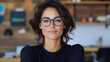 © VISUAL BACKGROUND - A woman wearing glasses in an office setting
