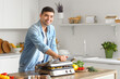 © Pixel-Shot - Young man cooking tasty sausages and vegetables on modern electric grill at table in kitchen