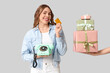 © Pixel-Shot - Young woman holding retro telephone, credit card and hands with gift boxes on grey background. International Women's Day