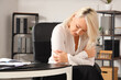 © Pixel-Shot - Mature businesswoman experiencing menopause at table in office