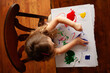 © Cavan Images - Above toddler blonde curls painting at wooden table
