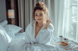 © Di Studio - woman in white bathrobe sitting on bed