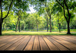 © Victor - Empty wooden table with a lush green park background. Table top product display showcase stage. Image ready for montage your text or product.