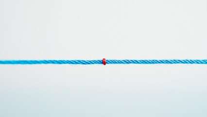 Wall Mural - minimalist blue rope with a single red knot on white background