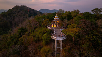 Wall Mural - Aerial view of Sunset above Khao Rang viewpoint. view of a town nestled among lush green mountains at sunset, with a Pavilion structure perched on the hillside at Phuket town at Dusk