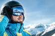 © verona_studio - A snowboarding enthusiast in bright winter gear overlooks a snowy mountain range, reflecting the pristine scenery in his goggles. Blue skies and snowy peaks frame this exhilarating outdoor adventure.