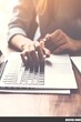 © tahu - Woman's hands typing on laptop keyboard.