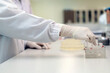 © nuengneng - A close-up view of a scientist's hand wearing a glove, manipulating samples in a laboratory setting