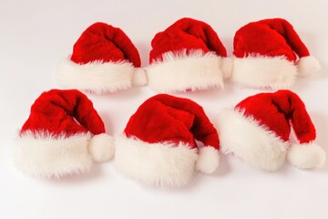 Wall Mural - Six red and white Santa hats on a white surface, ideal for festive or holiday-themed projects