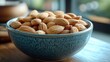 © Fotograf - A blue bowl filled with almonds sits on a wooden table