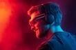 © woters - Young man enjoying music with neon-lit headphones in vibrant colored lighting during an evening event