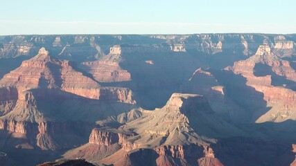 Wall Mural - Witness stunning red rock formations and vast chasms as visitors marvel at the Grand Canyon's natural wonders under a clear blue sky in Arizona.