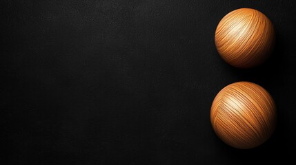 Two wooden spheres on black background, copy space