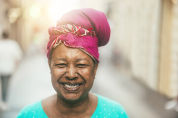 Wall Mural - Happy african senior woman smiling on camera wearing traditional clothes - Joyful elderly lifestyle and travel vacation concept - Focus on face