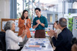 © Wasana - A group of people are clapping in a meeting room