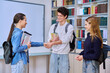 © Valerii Honcharuk - Meeting of classmates in high school library, teenagers shaking hands and greeting them
