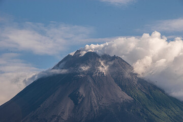 The smoking peak of Mount Merapi, the most active stratovolcano in Indonesia and has erupted regularly since 1548, located on the border between the Central Java and the Special Region of Yogyakarta. 