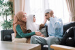 © DJ Creative Studio - Happy muslim parents and children relaxing together in the living room, embodying joy, islamic values, and family bonding while enjoying leisure activities during the weekend.