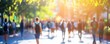 © SKIMP Art - A blurry, out-of-focus background of students walking on campus with sunlight filtering through the trees Generative AI