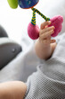 © Vitalina - Newborn babys hand touching hanging toy. Fine motor skills concept. Closeup, selective focus.