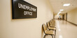 © A2Z AI  - Waiting area at an unemployment office.  Empty chairs line a hallway, leading to a further office. A sign clearly marks the location.
